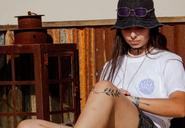 Modelo con remera Ride & Shine sentada en un balcón
